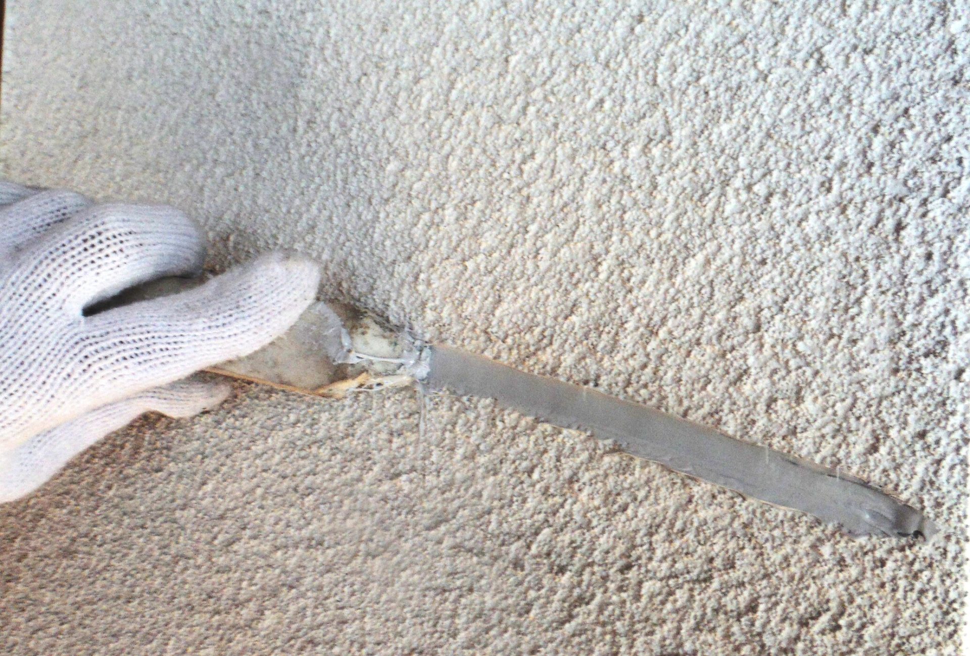 弾性フィラーを充填後、モルタル壁のクラック部分を均している補修工程